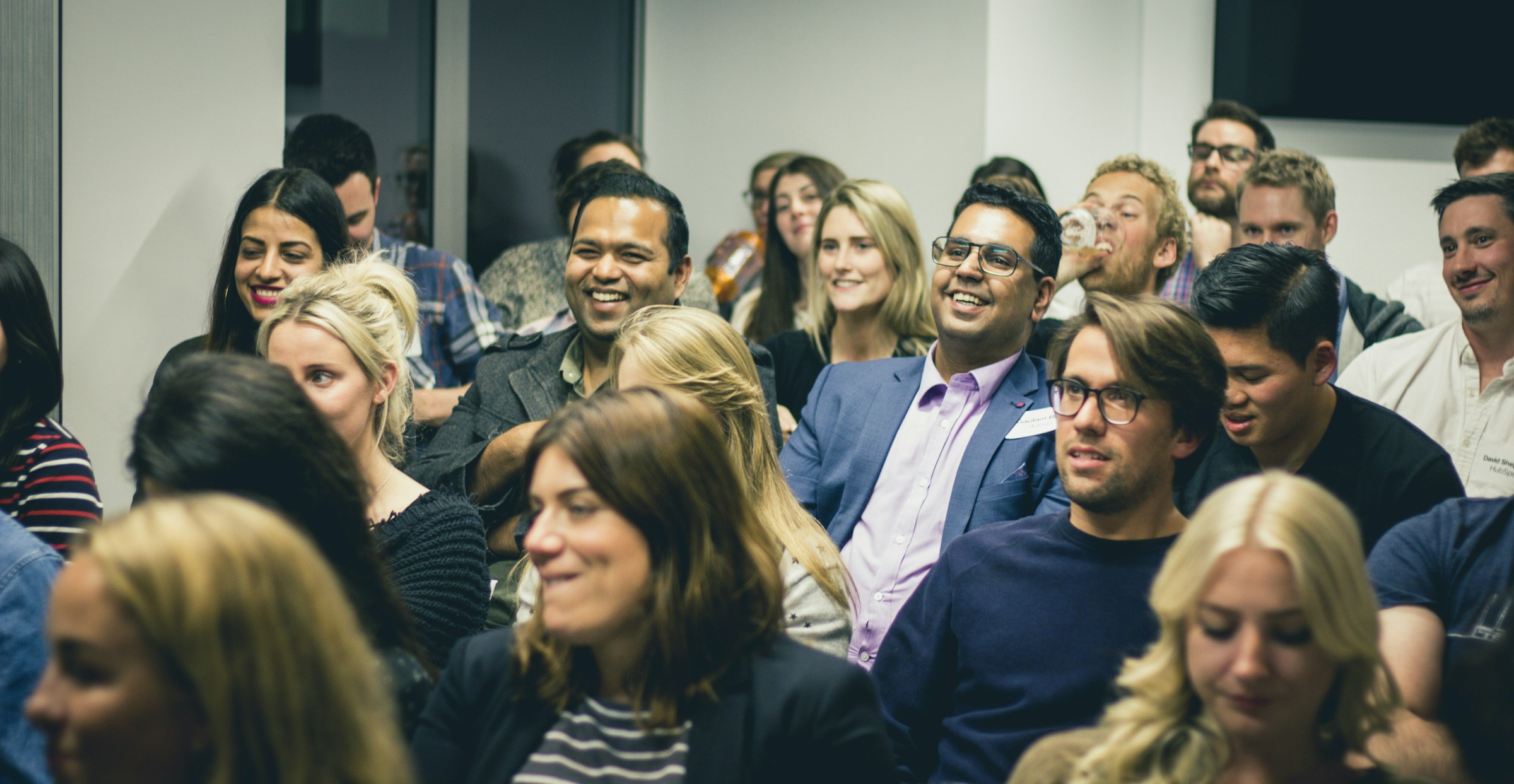 Colleagues sitting close together listening to a speaker at a company session